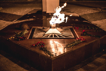a piercing wind sways the flame of eternal flame at the monument to the Second World War