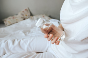 Transparent bottle made of eco-plastic with drinking water in female hands