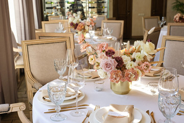 Luxury cozy autumn wedding table decoration in the restaurant. Fresh and dried flowers, roses,...