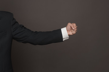 Man in formal fuit showing fist close up side view.
