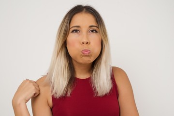 Beautiful young woman puffing cheeks with funny face. Mouth inflated with air, crazy expression.