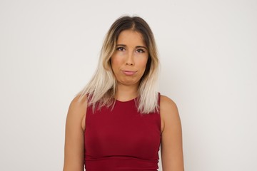 Obraz premium Gloomy, bored girl frowns face looking up, being upset with so much talking hands down, feels tired and wants to leave. Angry sullen woman standing indoors.
