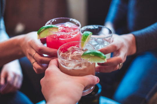 Friends toasting (cheers) with margaritas of different flavors
