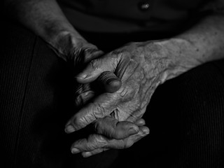 Elderly woman folded her hands on her knees