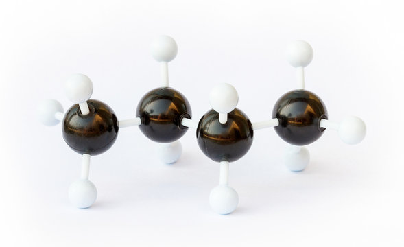 Plastic ball-and-stick model of a butane (chemical formula C4H8) molecule on a white background. Butane is commonly used as fuel.