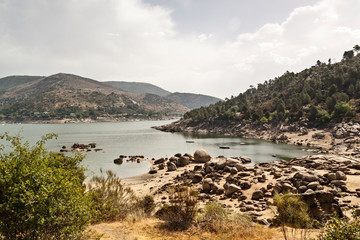 Burguillo reservoir in summer. Beach and mountains. El Tiemblo Natural Park in Ávila, Castilla y León.