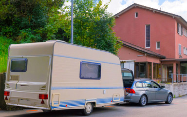 Car with caravan on road in Switzerland reflex