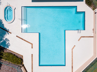 Outdoor swimming pool top view. Summer or spring vacations. Blue salt water in the pool and hot tub. Empty copy space.