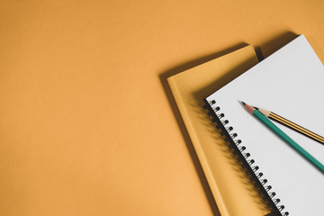 yellow book, pencil and spiral notepad on a yellow background. preparation of business report.