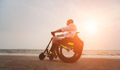 Fototapeta premium Disabled man in a wheelchair on the beach.