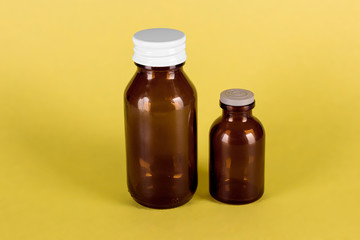 Medicine bottles big and small, yellow background