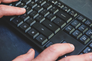 Close-up of typing man's hands on black keyboard. hand writing something on the computer keyboard.