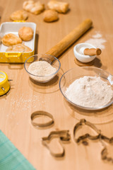 Ingredients for baking, rolling pin, flour in bowls, sugar, vanilla, molds and ceramic forms for baking, towel