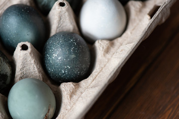 tray of eggs painted for easter. brown wooden table