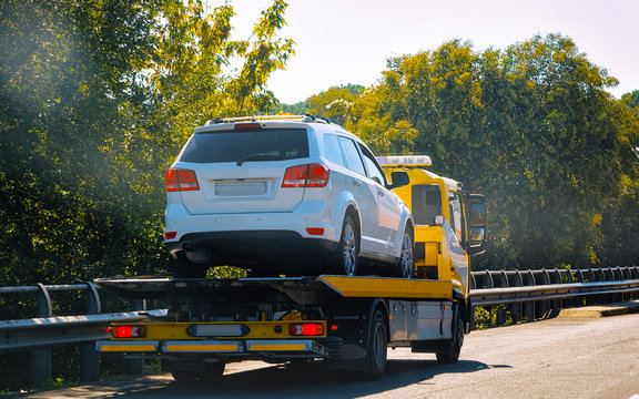 Tow truck with car on road reflex