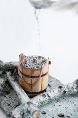 Birch sap in a wooden bucket, on a white background.
