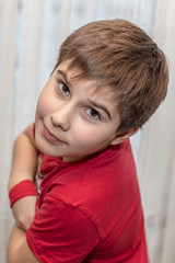 A dark-haired boy in a red T-shirt looks at you with his beautiful brown eyes.