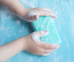 Fototapeta premium Soap with children's hands and foam, top view 