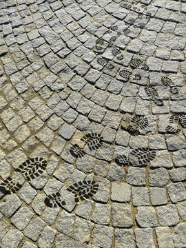 wet footprints of shoes on the pavement