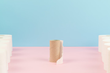 Conceptual image of finished toilet paper roll between new rolls.