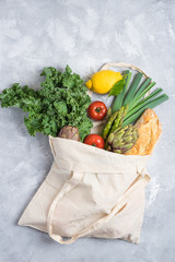 Delivery of healthy food during the quarantine period. Take away organic daily vegetables and fruits in the grey space. Clean food concept, healthy food, fitness food takeaway in a bag, top view.