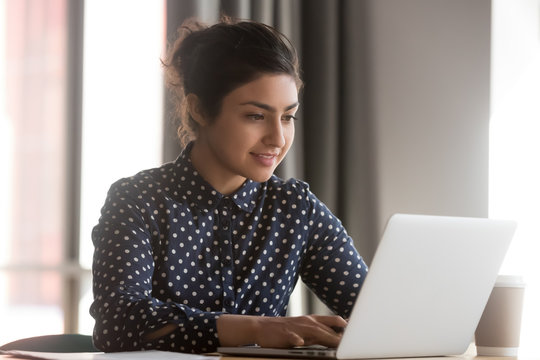 Indian Woman Sitting At Desk In Office Working On Laptop Typing Business E-mail, Check Media News, Solve Current Work-related Issues Distantly, Wireless Modern Tech Usage, Communication Online Concept