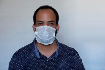 Covid-19 Corona virus pandemic facemask personal protective equipment mask mixed race male with...