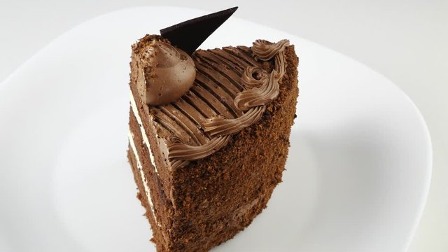 Cut a piece of chocolate cake.Cake on a white plate.