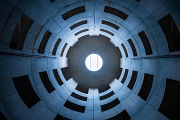 Empty concrete spiral space building, Natural light from ceiling, concrete windows, low-angle view