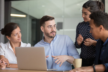 Multi-ethnic professionals colleagues gather together discuss startup ideas, diverse associates...