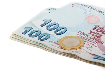 Turkish lira coins in a row on hundred banknotes.