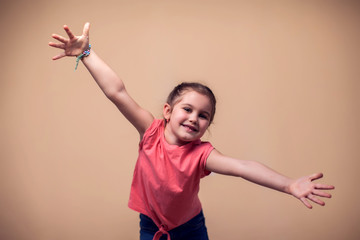 A portrait of happy kid girl showing embrace at camera. Children and emotions concept