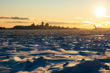View of Quebec city over the frozen river, sunset time