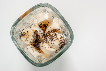 Ingredients for smoothies. Bananas, chia seeds in blender on a white background.
