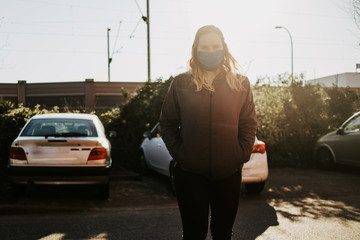 Woman wearing a self-made face mask walking though empty streets during pandemic situation of Covid-19