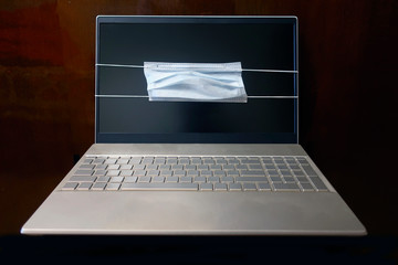 quarantine: turned off desktop laptop with medical mask on display