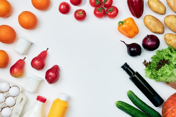 Groceries on white background arranged around the frame: pumpkin, potatoes, onions, cucumbers, lettuce, bell peppers, tomatoes, bottle of olive oil, milk, mustard, eggs, yoghurt, oranges, pears
