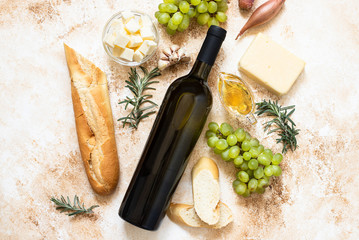 A bottle of white wine, grapes, cheese, butter, honey, baguette, shallot and rosemary. White wine...