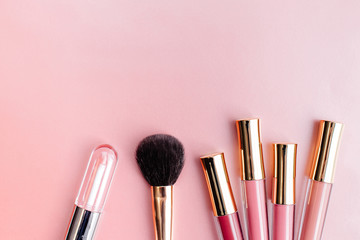 Flat lay composition with products for decorative makeup on pastel pink background