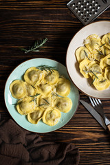 Traditional italian ravioli with rosemary and parmesan served on a rustic wooden table. Italian pasta. Top view, copy space