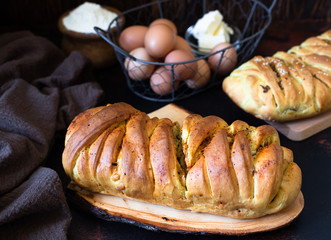 A traditional salty pie of Russian cuisine called kulebyaka. Ingredients for the dough butter, flour, eggs. Two closed pies with different fillings, the first with meat and mushrooms, the second with 