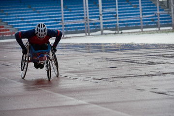 Determined paraplegic sportsman racing in handcycle at outdoor stadium