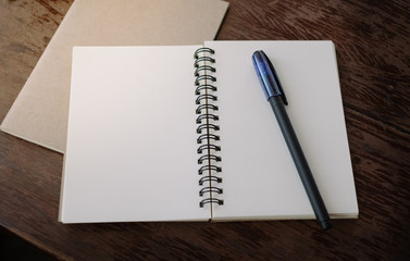 Office desk table top view. Notepad with blank pages on wooden table