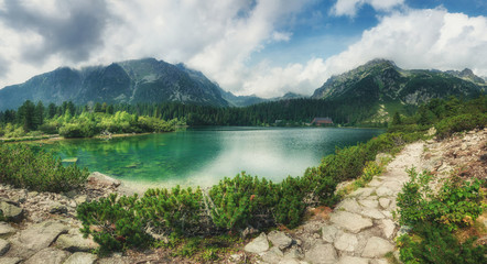 Panoramic view of mountains and  Poprad Lake (Popradske pleso) in High Tatras National Park. Slovakia. Europe. Mountain hiking. Concept of travel lifestyle, harmony with nature. Nature background.