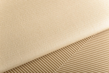 Carton or cardboard packing material. Texture of corrugated paper sheets made from cellulose. Supplies for creating boxes and packaging. Pasteboard background. Natural brown cardboard surface.