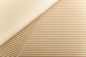 Carton or cardboard packing material. Texture of corrugated paper sheets made from cellulose. Supplies for creating boxes and packaging. Pasteboard background. Natural brown cardboard surface.
