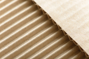Carton or cardboard packing material. Texture of corrugated paper sheets made from cellulose. Supplies for creating boxes and packaging. Pasteboard background. Natural brown cardboard surface.