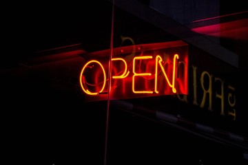 Cartel de neon luminoso rojo que indica open