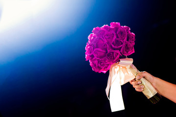 Noiva comemorando o seu casamento com buquê de flores rosas. Sonho realizado para casal que planeja o casamento - obrazy, fototapety, plakaty