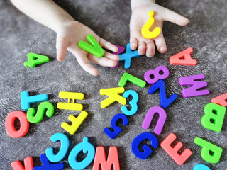 Kid is studying letters and numbers. Color alphabet. Preschool education.